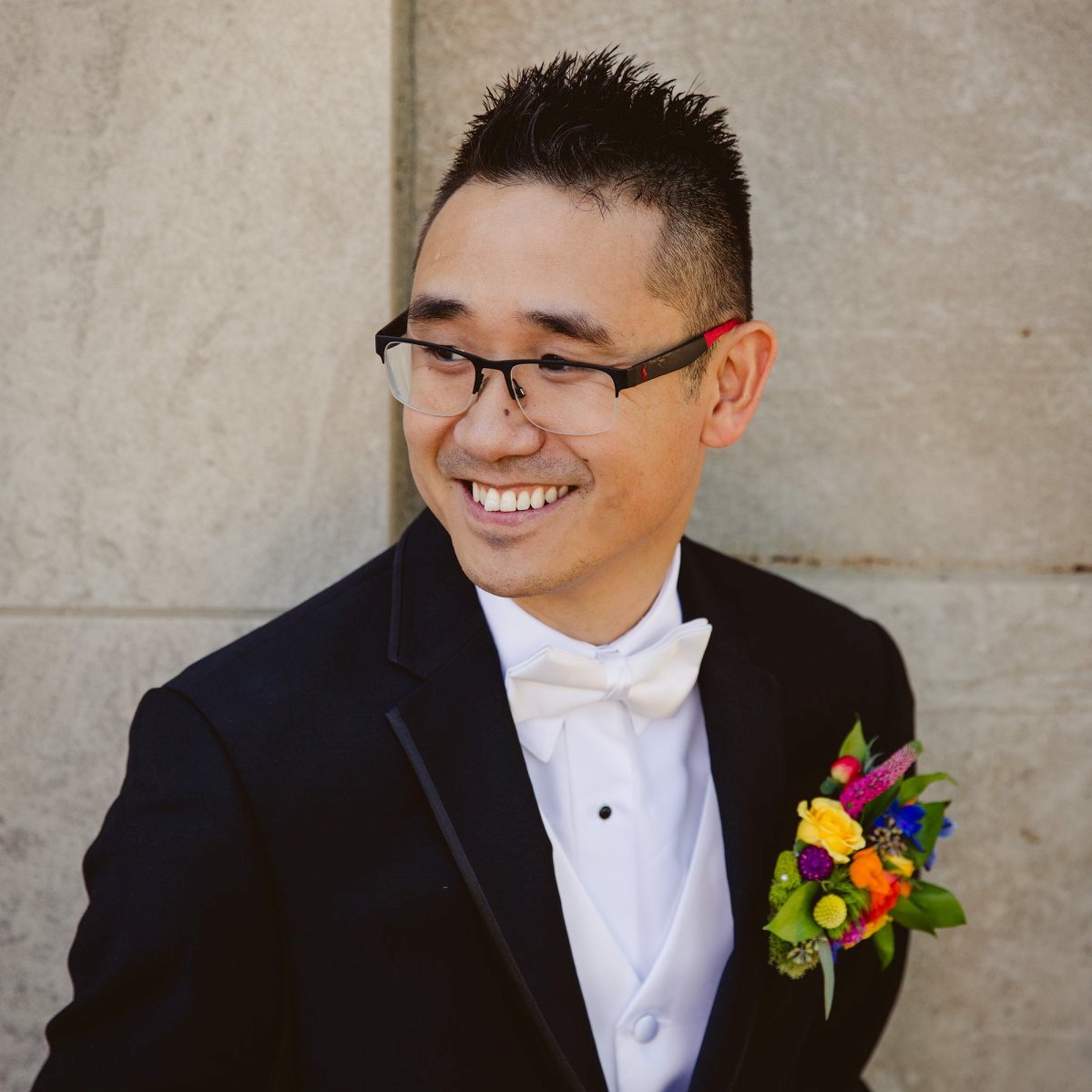 Asian in a tux smiling